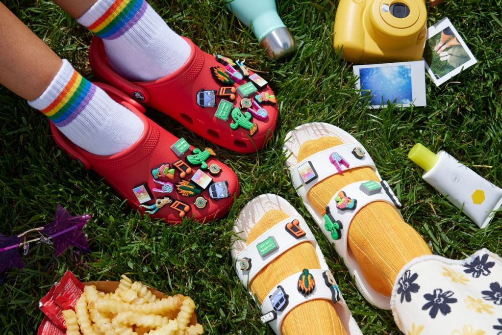 Crocs Clogs and Sandals shown on feet at a picnic with food, camera, snacks