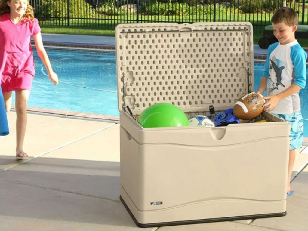 kids getting pool toys out of a Lifetime Heavy-Duty 80 Gallon Plastic Deck Box by a pool