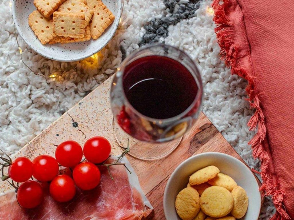 Michel et Augustin Gourmet Cheese Crackers shown in bowls with a charcuterie board and glass of wine