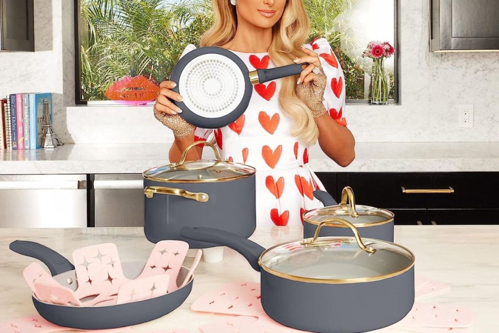 Paris Hilton Epic Nonstick Pots and Pans Set shown in kitchen with Paris holding 1