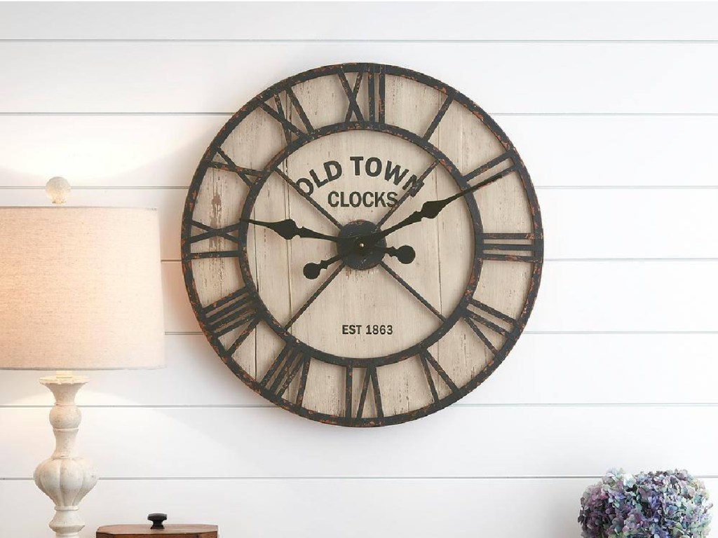 Home Decorators Collection Rustic Black Metal and Natural Shiplap Decorative Wall Clock displayed in the living room next to a lamp