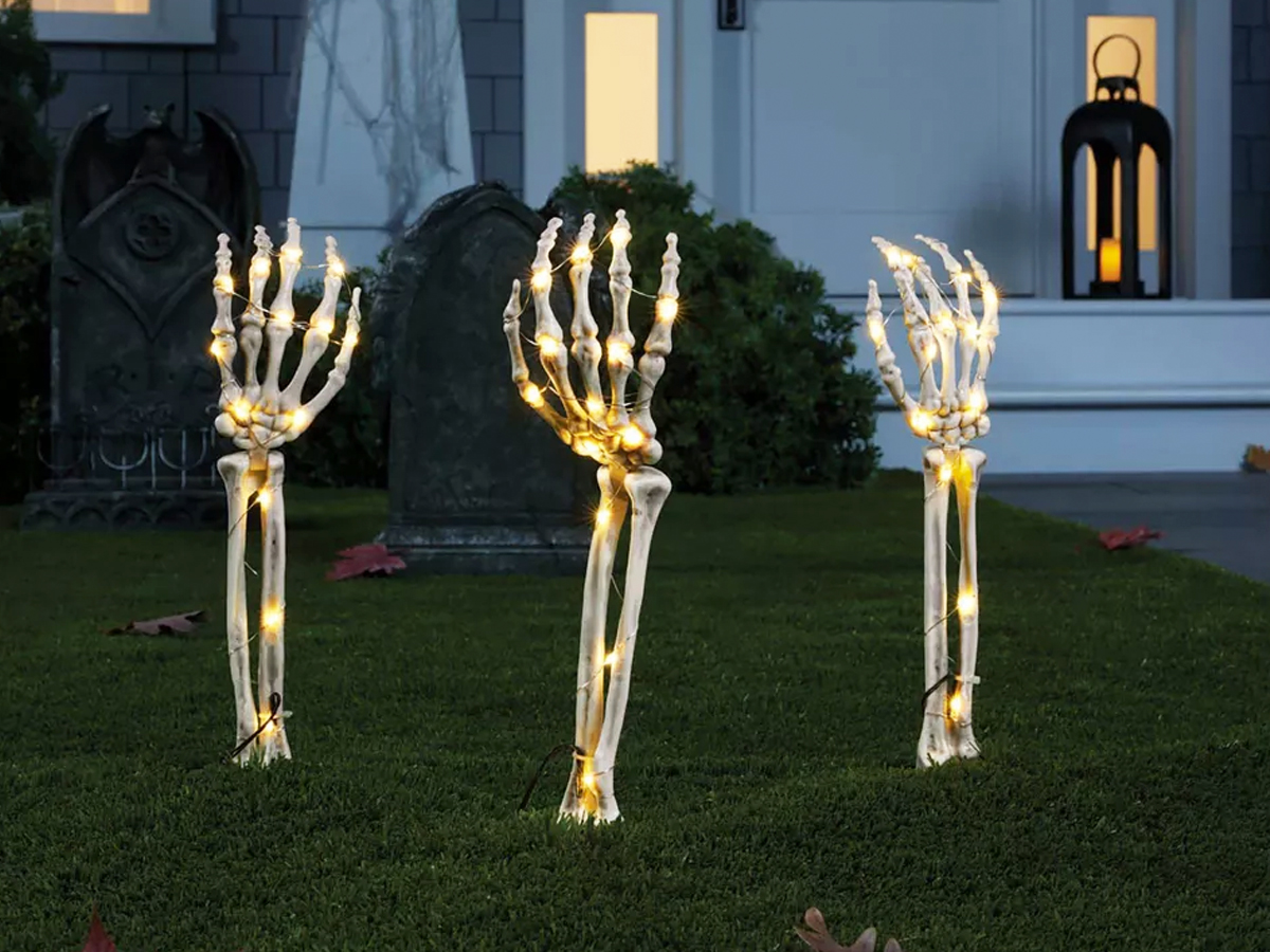 three light up skeleton hands coming up from lawn
