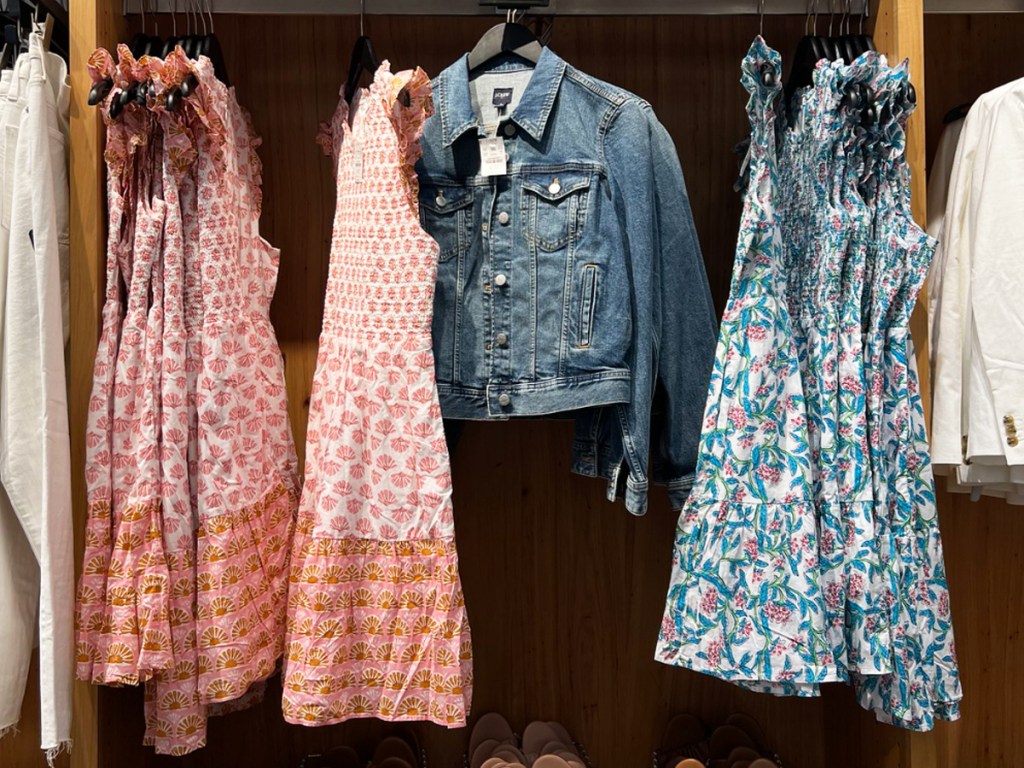 dresses and jean jacket hanging on store display