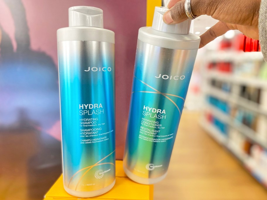 hand grabbing a liter bottle of joico hydra splash