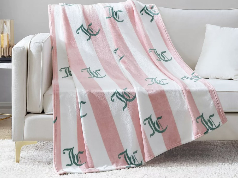 light pink and white striped throw blanket draped over a couch