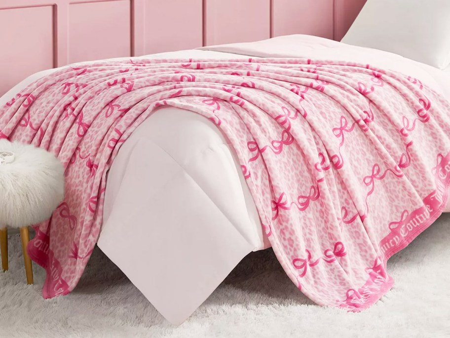 pink bow throw blanket draped over a bed