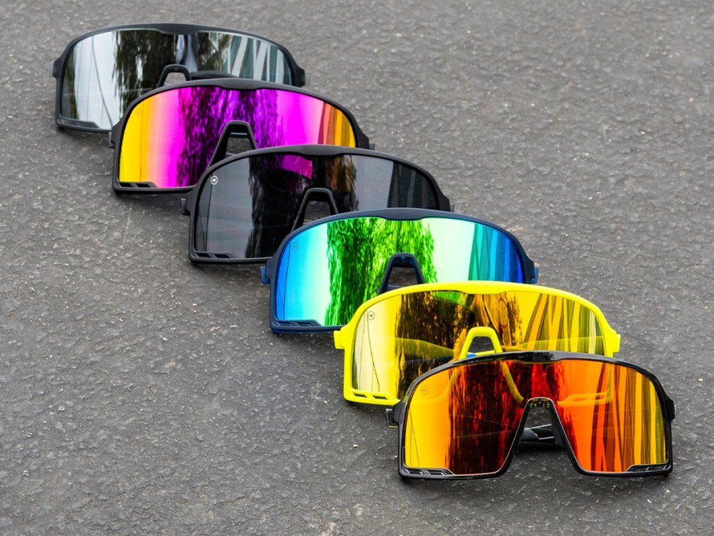 row of sunglasses in various colors on street