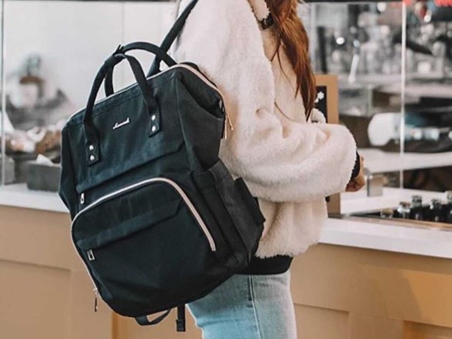 woman wearing black lovevook laptop backpack in restaurant