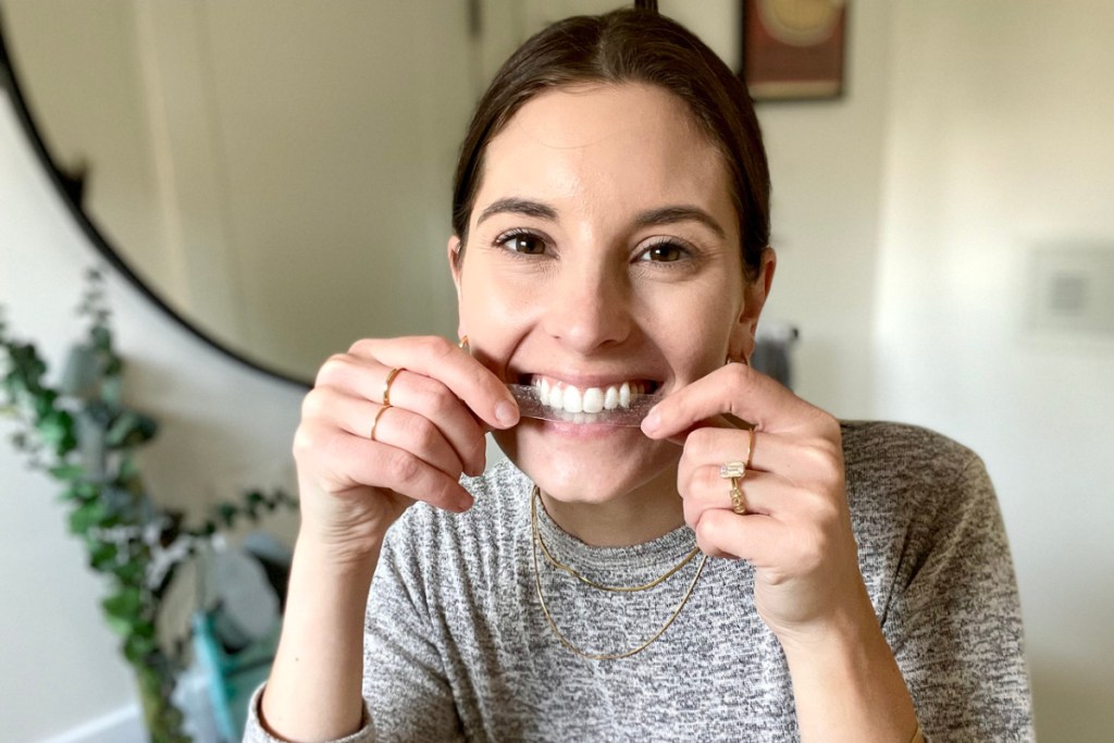 woman applying Lumineux Teeth Whitening Strips