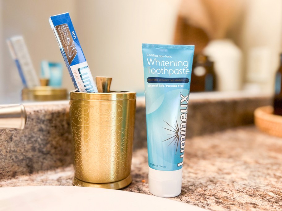 Lumineux Teeth Whitening Toothpaste tube on counter next to bathroom sink