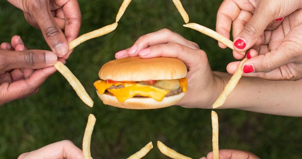 People making a star with french fries around a McDonald's double cheeseburger