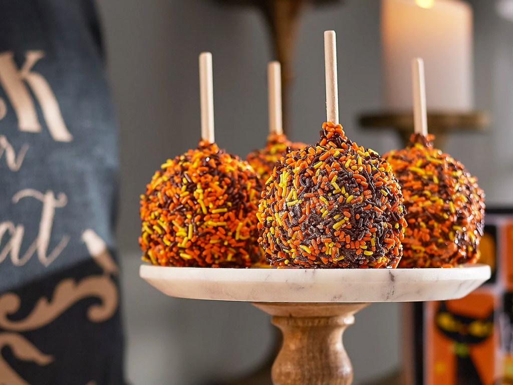 caramel apples in fall sprinkles on a display stand