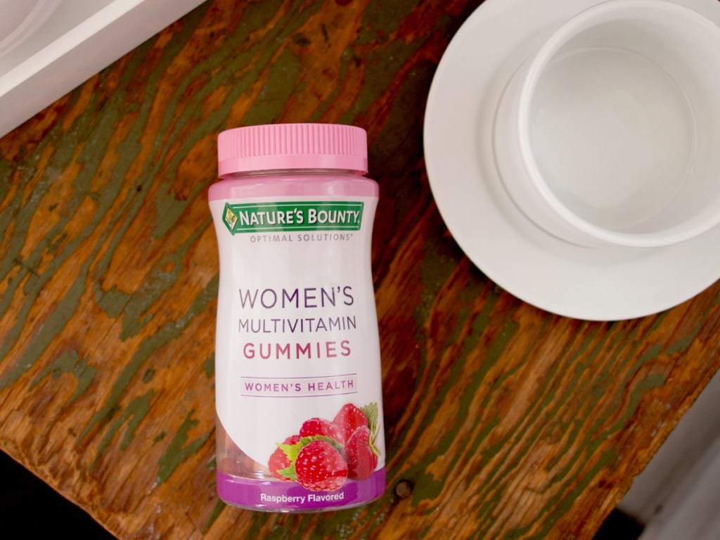 bottle of Nature's Bounty Women's Multivitamin Gummies on table next to white mug