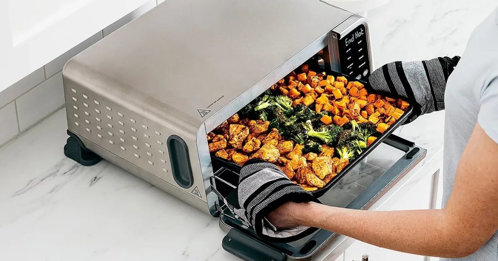 taking a sheet pan meal out of an air fryer