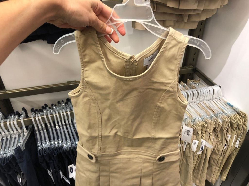 Hand holding a hanger with a uniform dress on it from Old Navy