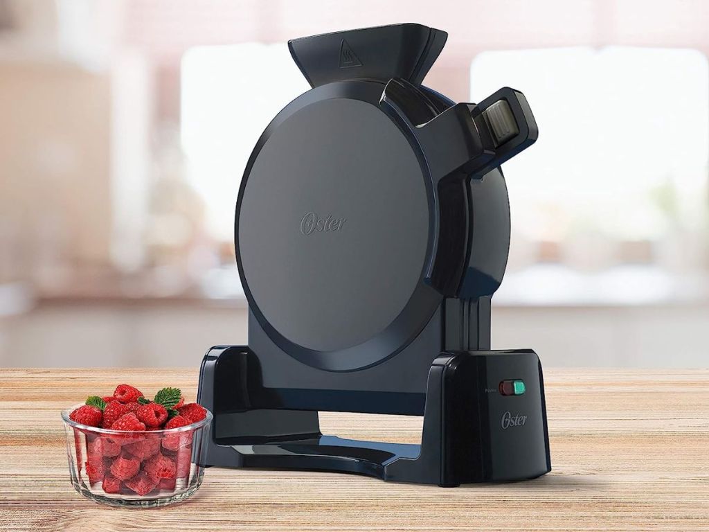 Waffle maker with a bowl of berries next to it