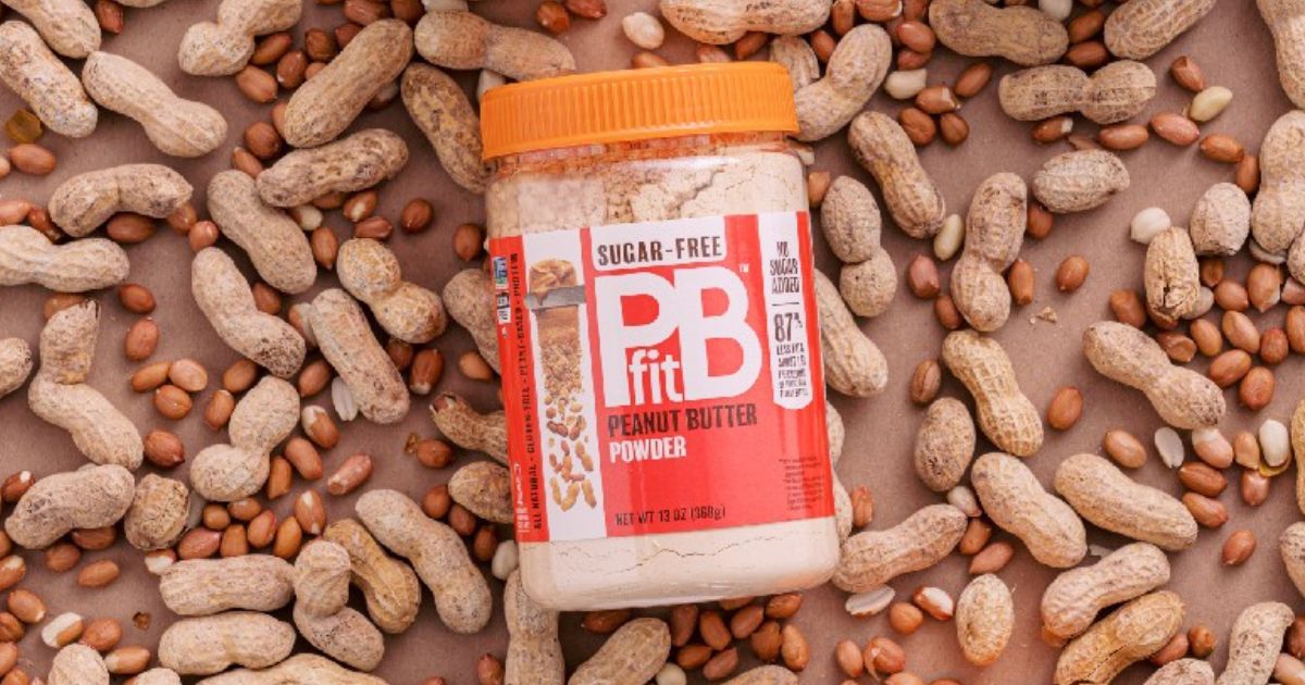 Jar of PBfit Sugar Free Powder on shelled and unshelled peanuts