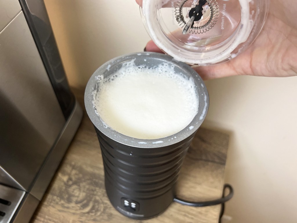 taking lid off milk frother with foam inside