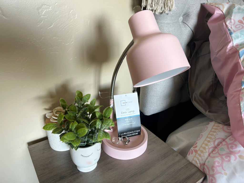 a pink mainstays LED desk lamp sitting on a college dorm room nightstand