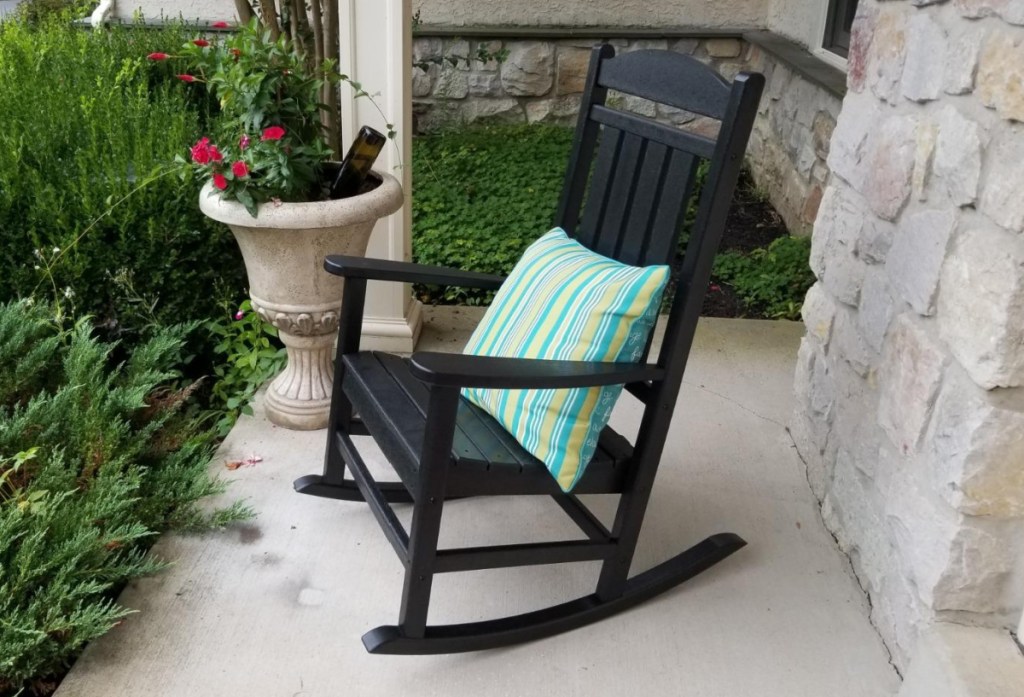 A Polywood outdoor rocking chair on a front porch