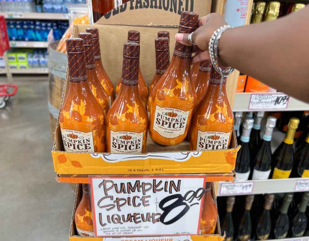 Hand grabbing a bottle of Trader Joes Pumpkin Spice Liqueur