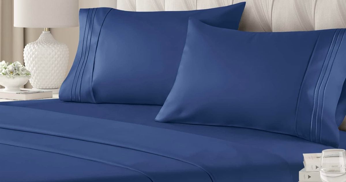 navy bluey sheet set on a bed with a quilted grey velvet headboard