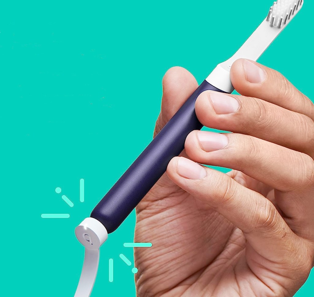 placing charger on navy blue electric toothbrush