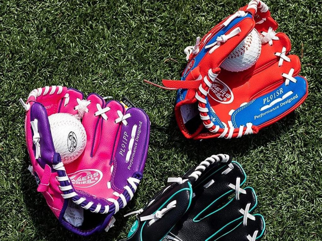 3 Rawlings gloves in the grass