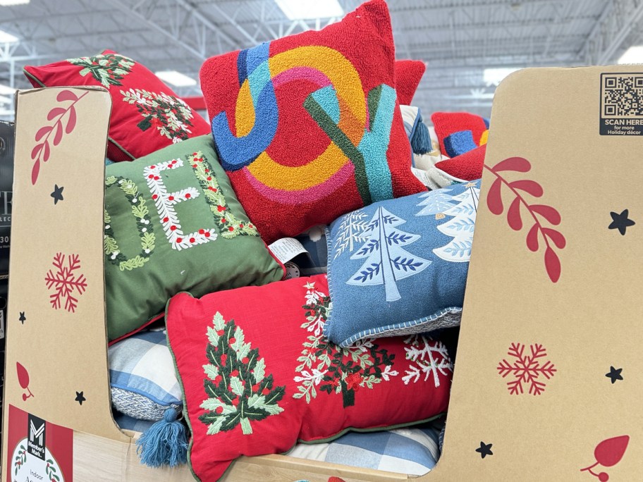 stack of holiday throw pillows in cardboard display