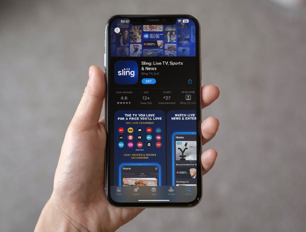 hand holding up a phone with the sling TV app