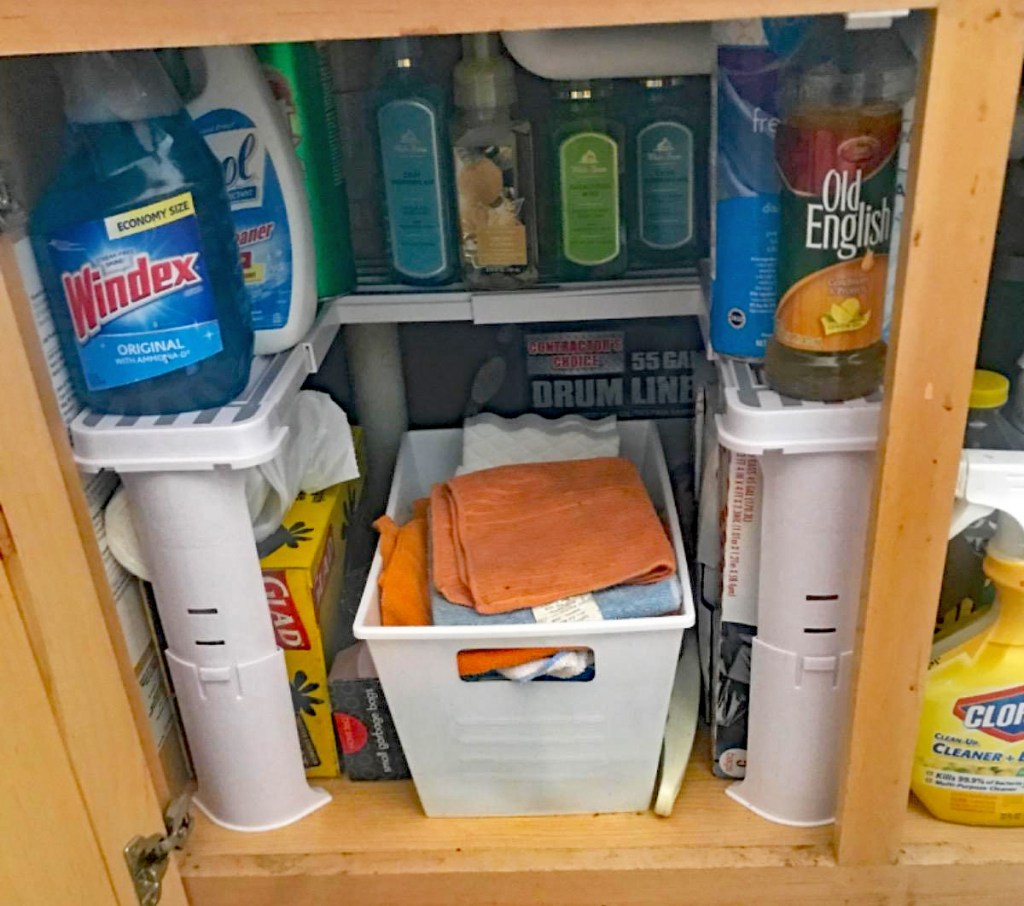 cleaning products on a white organizer in cabinet under bathroom sink