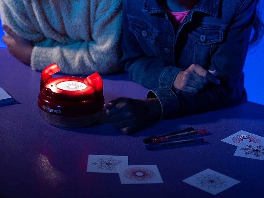 kids in dark playing with spirograph set