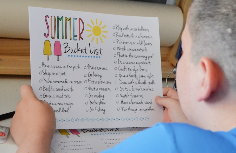 boy holding up his Summer Bucket List