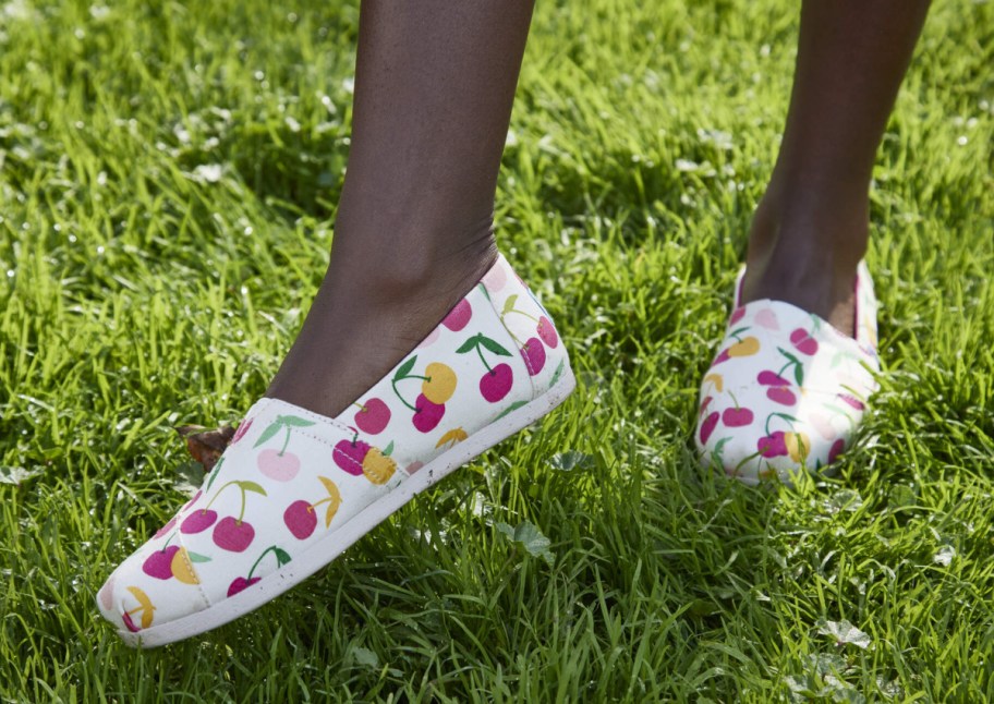 cherry print shoes on feet in grass