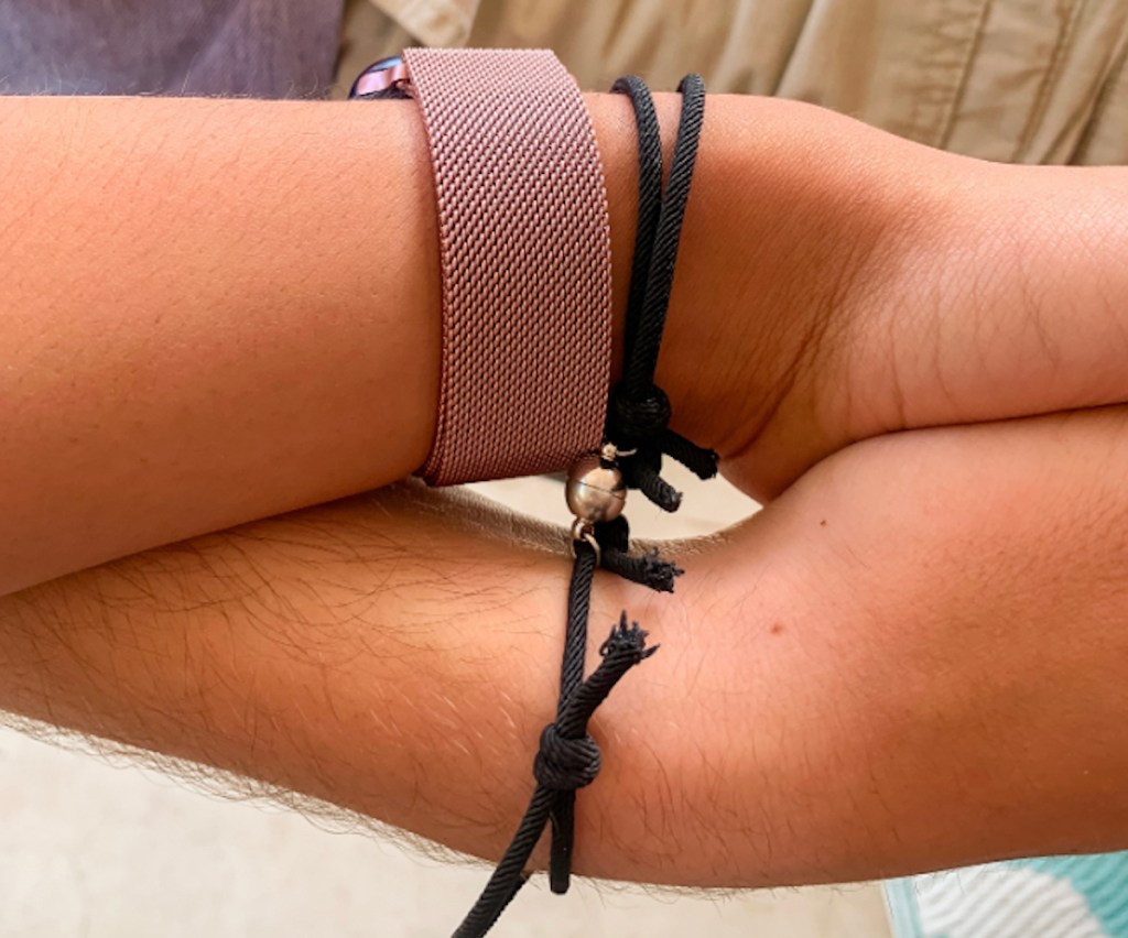 couple holding hands with linked matching bracelets