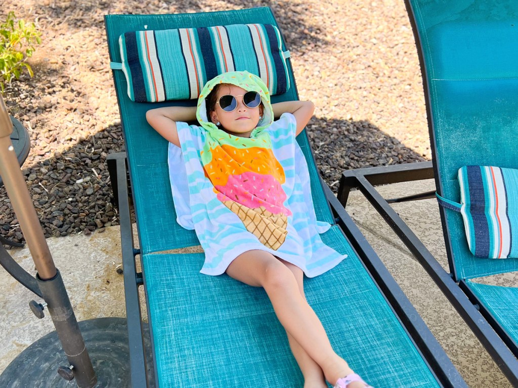 girl laying on lounge chair wearing ice cream print hooded towel