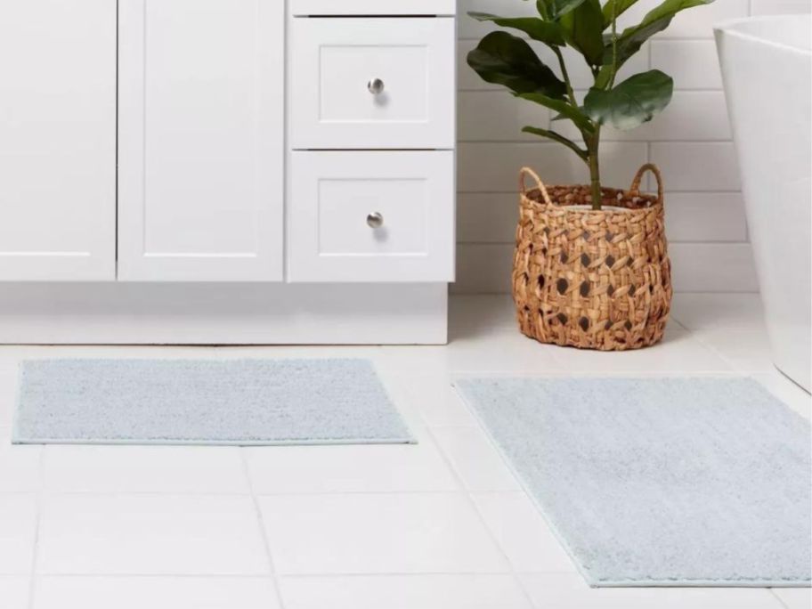 Two different size Threshold Quick Dry bath rugs on a bathroom floor