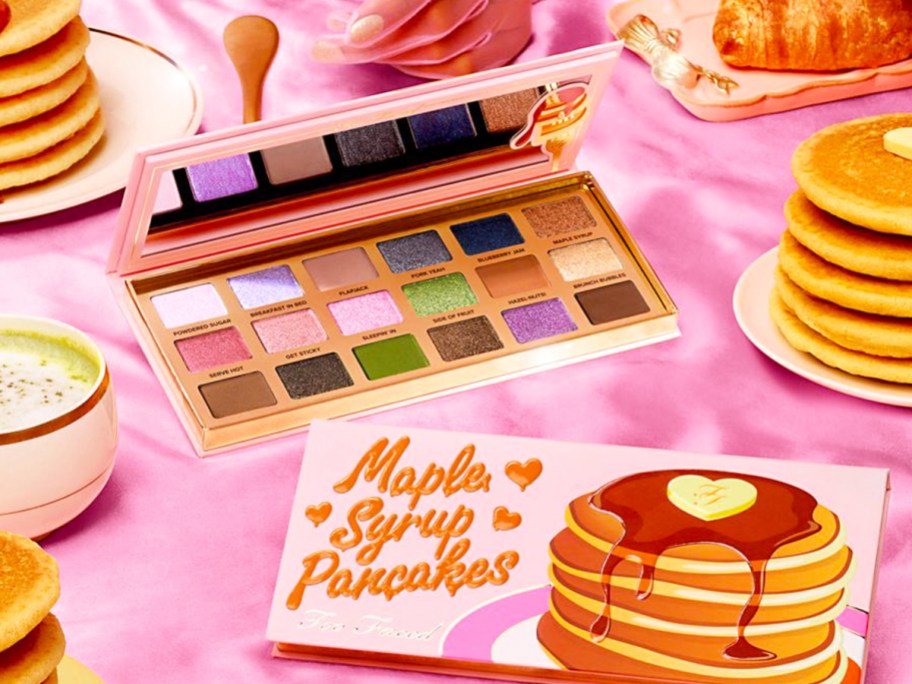 Too Faced Maple Syrup Pancakes Eyeshadow Palette on pink table with plates of pancakes