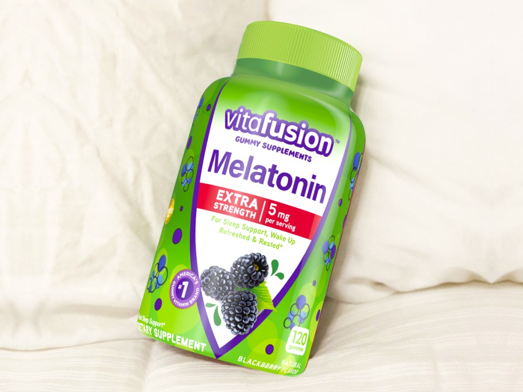 bottle of Vitafusion Extra Strength Melatonin Gummies in bed