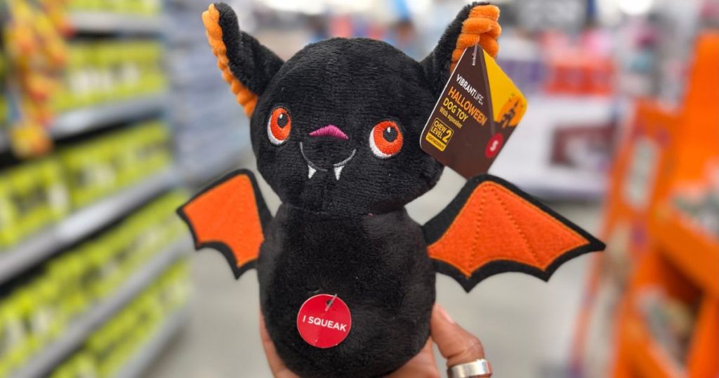 Hand holding a Squeaky bat pet toy from Walmart