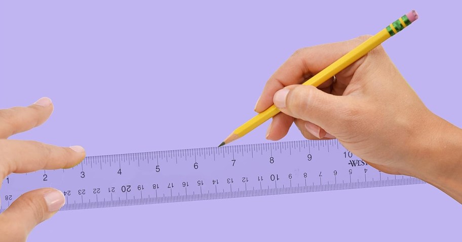 person using pencil and ruler to mark purple piece of paper