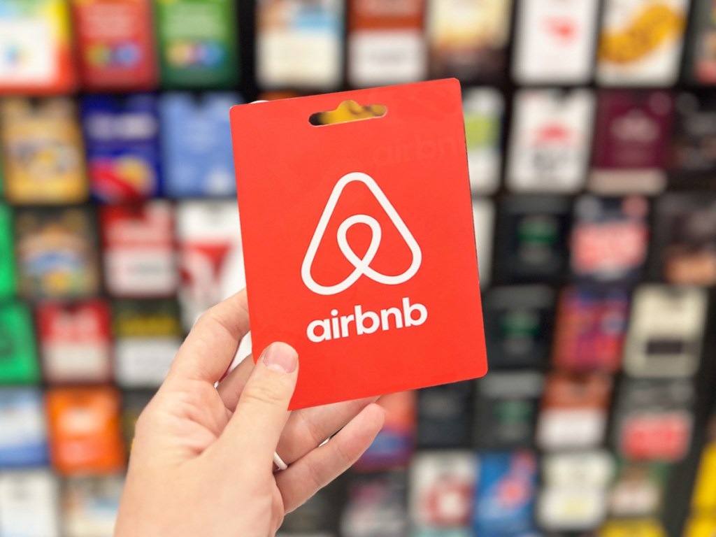 hand holding a red airbnb gift card