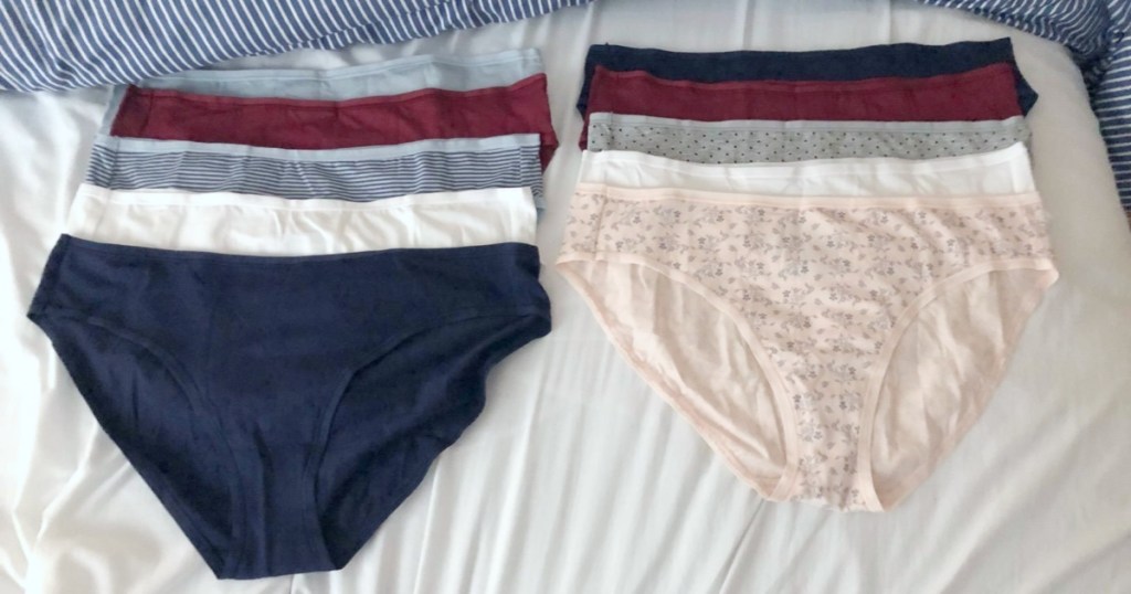 10 pairs of women's underwear laid out on bed