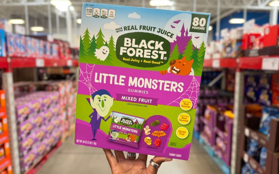 a womans hand grabbing a 80 count box of black forest fruit candies