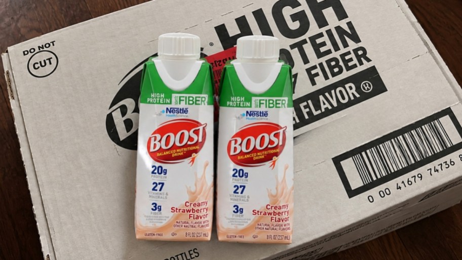 2 boost protein shake bottle on top of a case size box