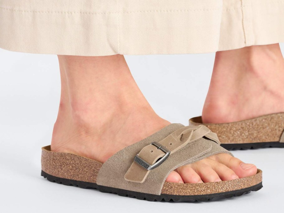 feet in tan slide sandal with braided detail