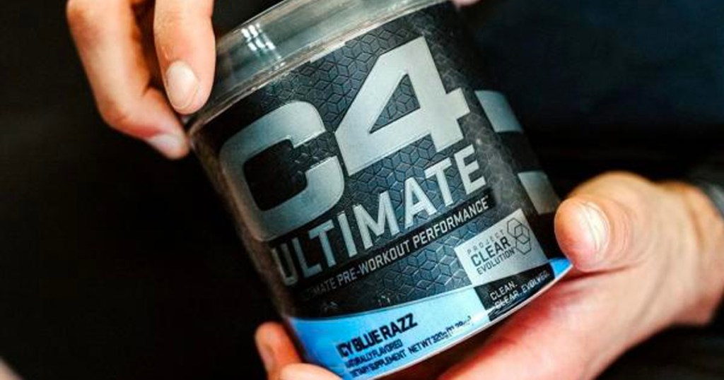 hands holding c4 ultimate pre workout container