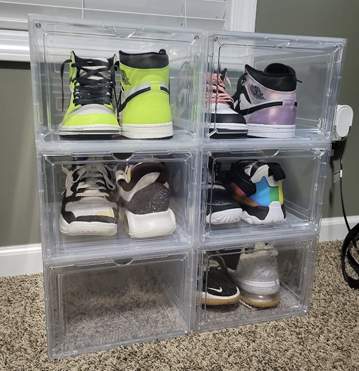 clear bins on carpet floor with various styles of nikes sneakers inside