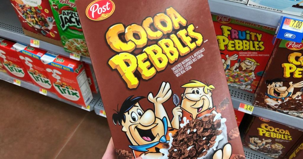 hand holding cocoa pebbles cereal box in store cereal aisle