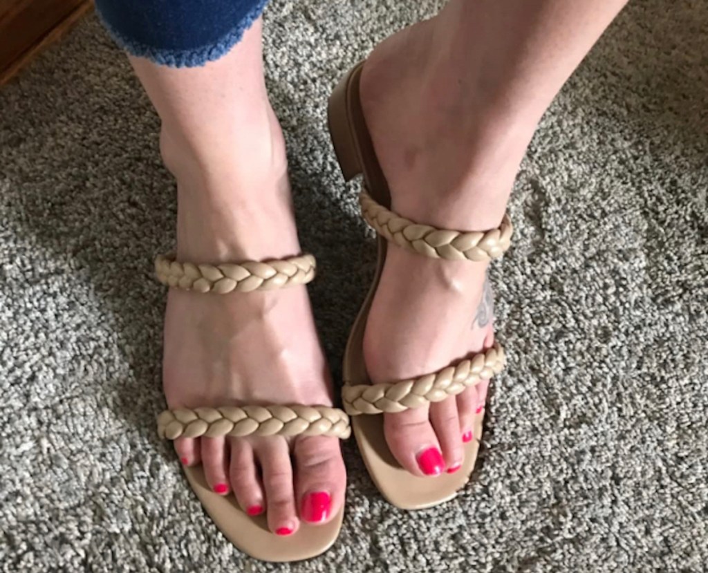 close up of feet wearing tan braided kitten heel sandals